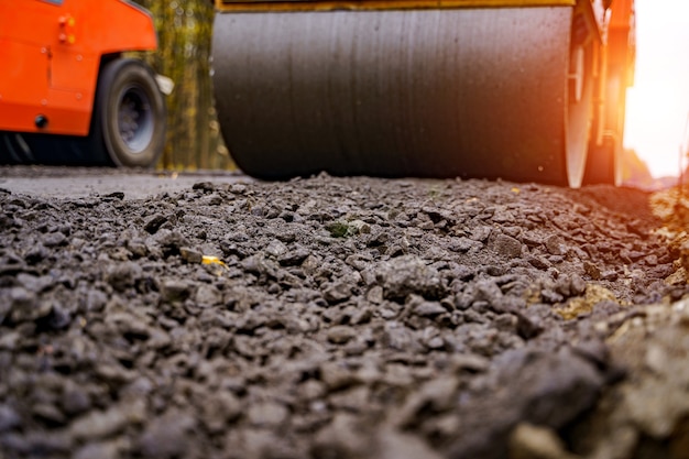 Fresh asphalt on highway construction site. Industrial pavement machine laying.