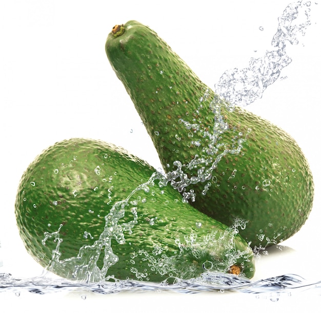 Fresh avocado falling in water