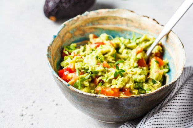 Fresh avocado tomato guacamole in a bowl.