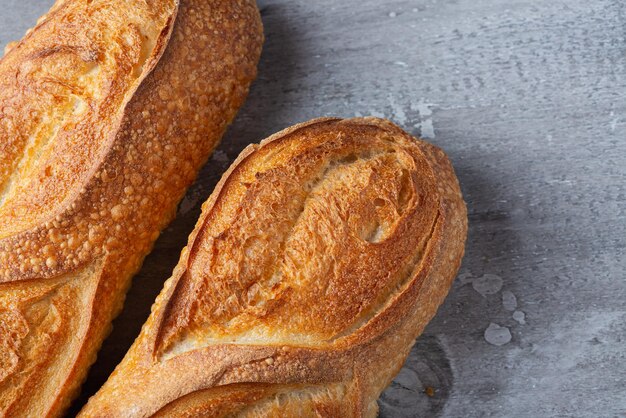 Fresh baked baguette loaves on wooden surface View from above with copy space