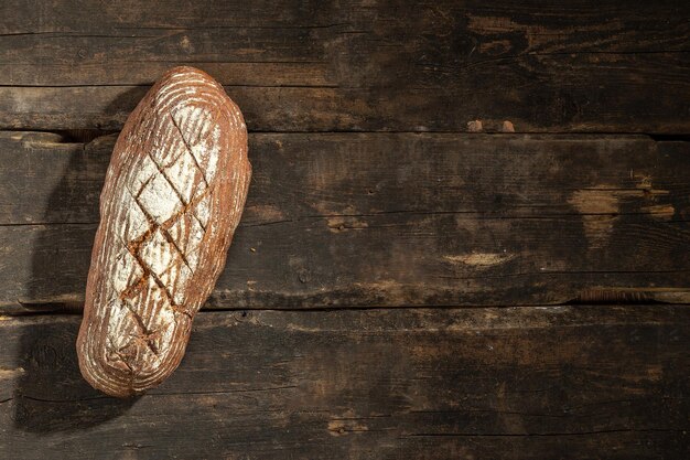 Fresh baked bread at brown wooden table brown coarse grain bread