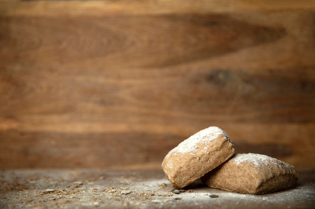 Fresh baked bread with flour on wooden table and background with copy space