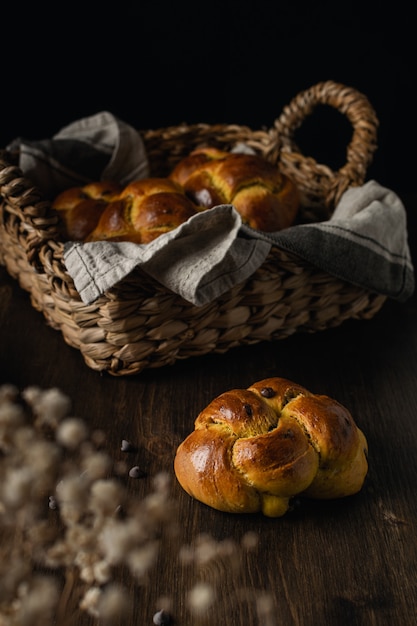 Fresh baked brioche with chocolate chips on dark wooden background