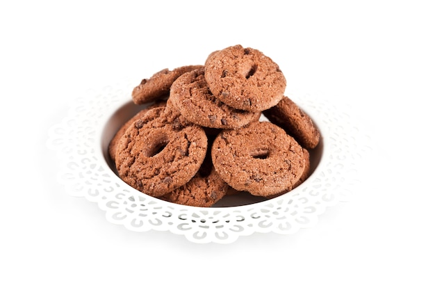 Fresh baked chocolate chip cookies heap on white plate isolated 