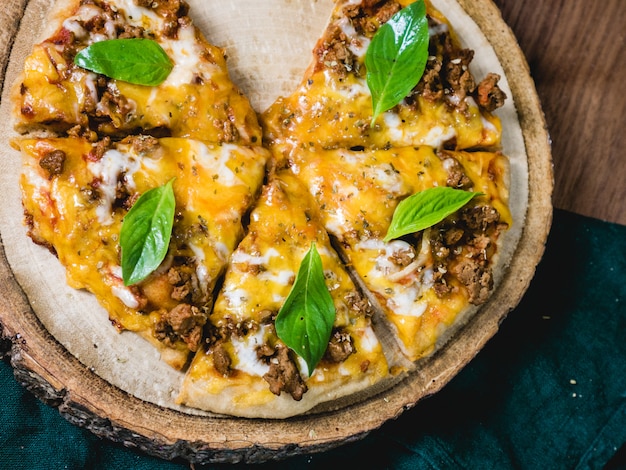 Fresh baked crisp pizza with meat cheese and fresh Basil leaf