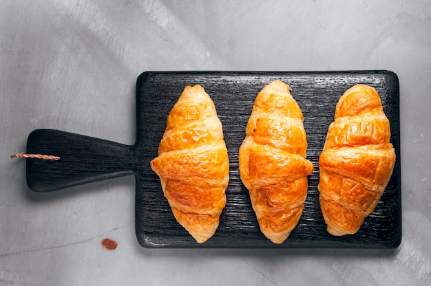 Fresh baked croissant sprinkled with powdered sugar on table