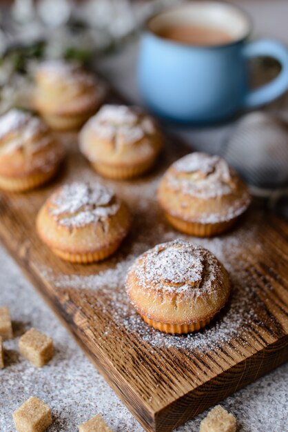 Fresh baked cupcakes of rice flour with banana and vanilla with a mug of hot chocolate. Delicious invigorating breakfast with hot chocolate and cupcakes