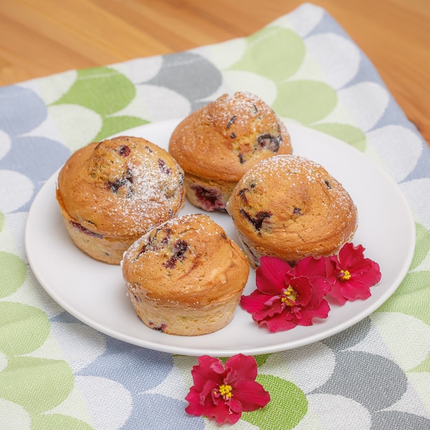 Fresh baked muffins or cupcakes powdered with sugar on dish