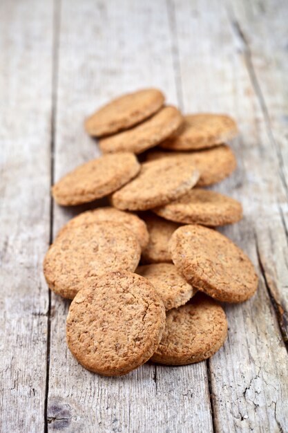 Fresh baked oat cookies on rustic wooden table.