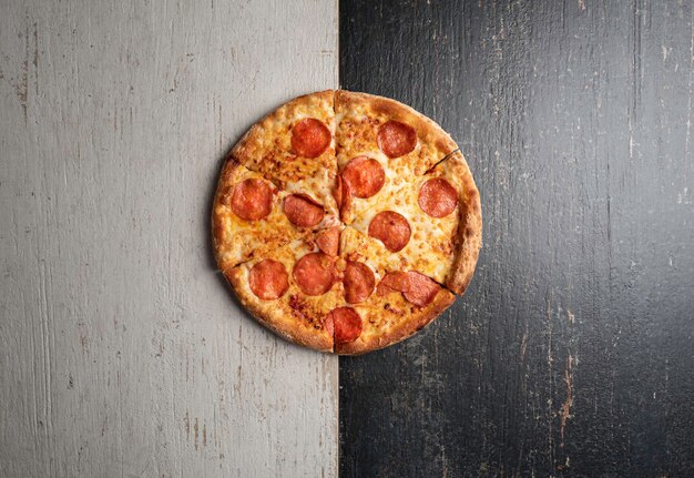 Fresh baked pizza with ingredients on a dark stone table