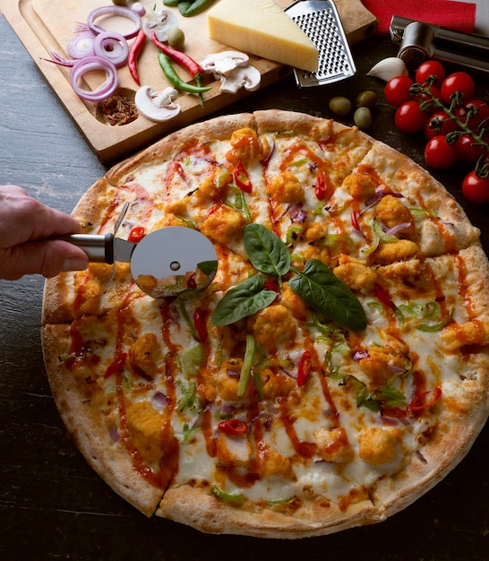 Fresh baked pizza with ingredients on a dark stone table