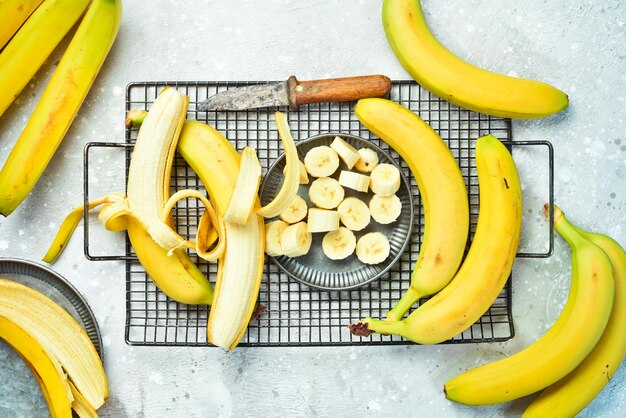 Fresh bananas sliced in a bowl Tropical bananas on a gray concrete background Top view