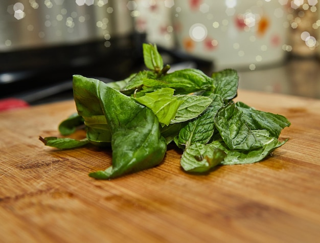 Fresh basil leaves lie on wooden board for cooking