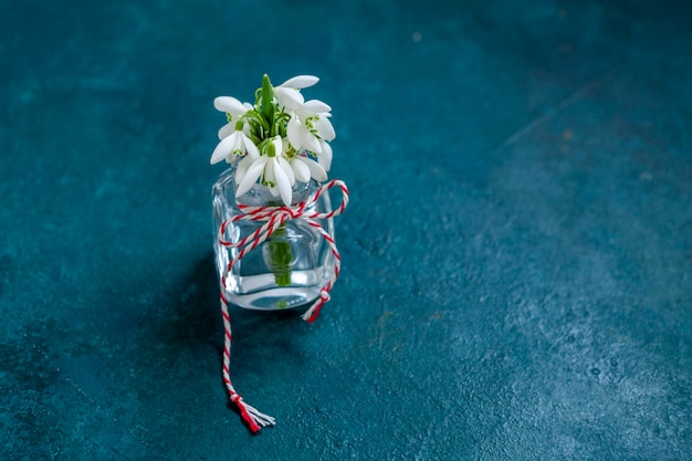 Fresh beautiful bouquet of the first spring forest snowdrops  flowers with red and white cord martisor