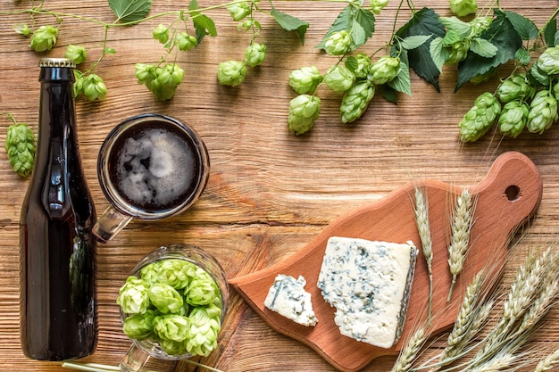 Fresh beer and the salty cheese on a wooden table