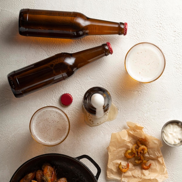 Fresh beer with fried shrimps on a light table top view