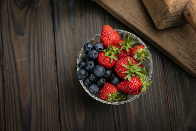 Fresh berries harvested on the farm are on a wooden table