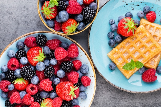 Fresh berries salad in a plate on a  wooden background 