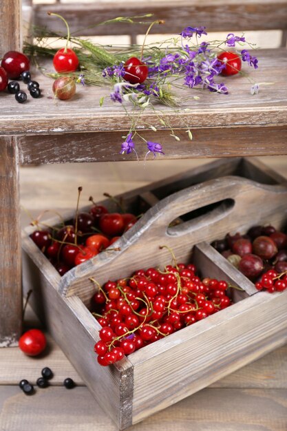 Photo fresh berries in wooden box close up