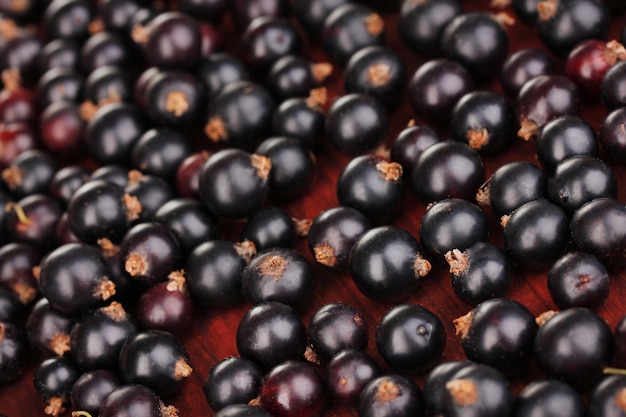 Fresh black currant on wooden background close up