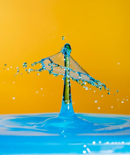 Fresh blue Water drop with droplet and rings on the yellow background