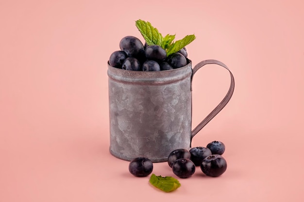 Fresh blueberries in a cup on pink background