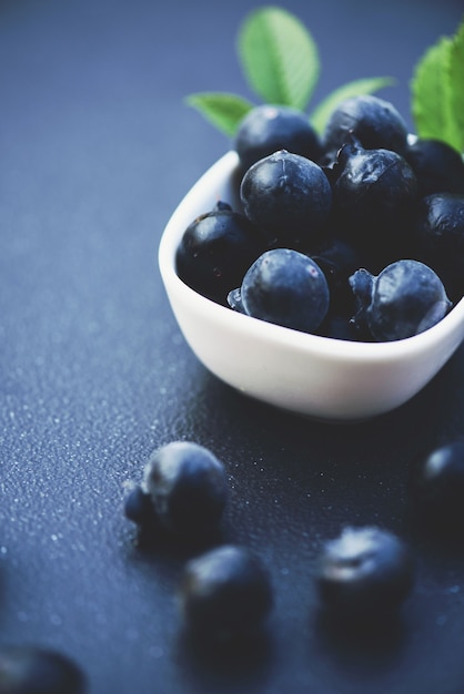 Fresh blueberries  with green leaves  on texture background