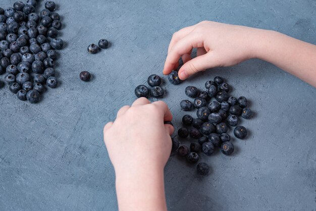 Fresh blueberries with kid's hands