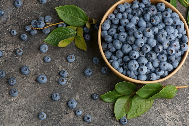 Fresh blueberries with water drops in a wooden bowl view from above the concept of healthy and diet