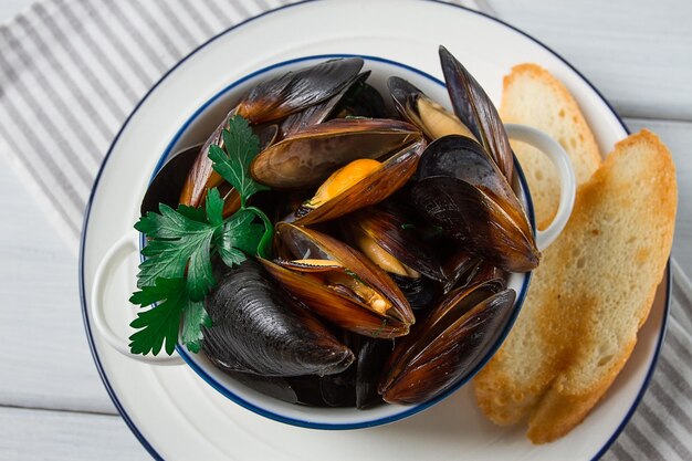 Fresh Boiled mussels Black Sea with white bread on a white wooden table no people