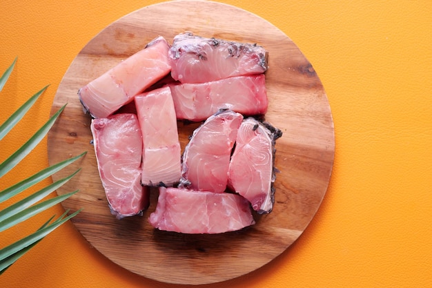 Fresh boneless skinless cod filet on chopping board