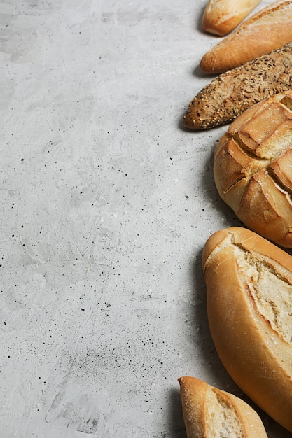 Fresh bread on a gray concrete background. Top view with copy space