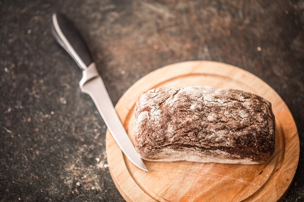 fresh bread in hands closeup on old wooden table