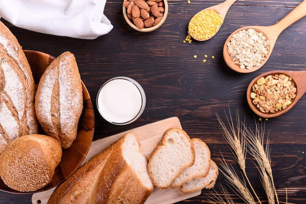 Fresh bread with milk on black wooden table.