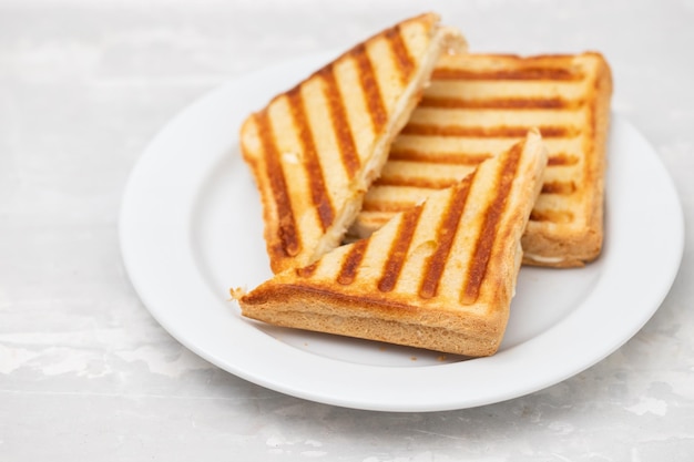 Fresh breakfast toasts on white plate on ceramic