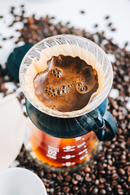 Fresh brewed coffee in a cup using Alternative method, with pour over dripper and paper filter.