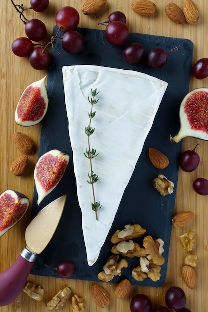 Fresh Brie cheese slice on stone board