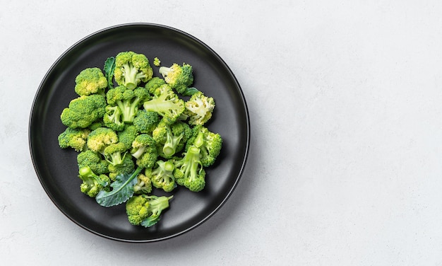 Fresh broccoli in a black plate on a gray background Healthy healthy food