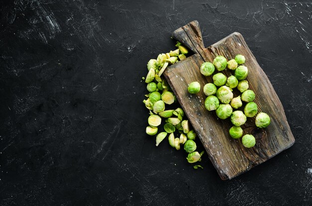 Fresh Brussels cabbage on a black background Vegetables Top view Free space for your text