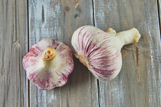 Fresh bulbs of garlic stacked on wooden gray background