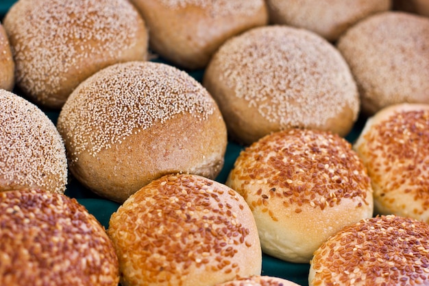 Photo fresh buns from yeast dough with sesame and poppy seeds