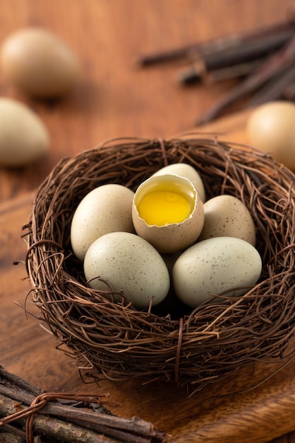 Fresh button quail eggs in a nest on wooden table background