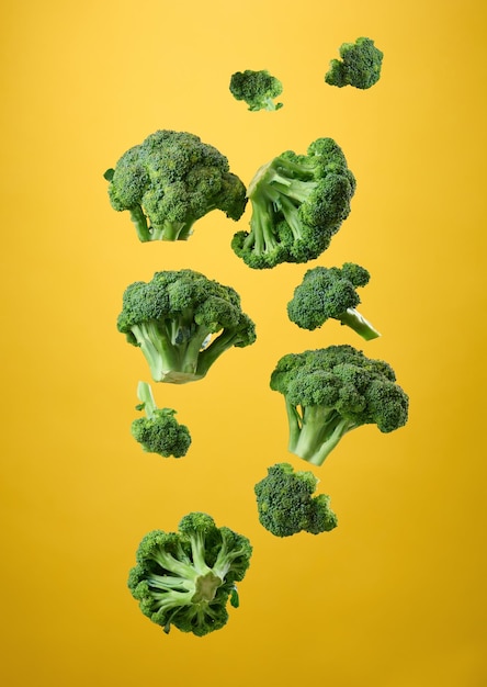 Fresh cabbage broccoli flies on a yellow background