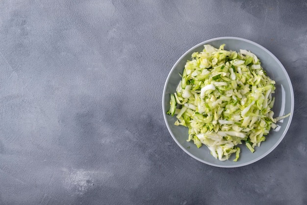 Fresh cabbage salad with cucumber and dill on a plate Top view text space