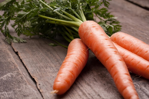 Fresh carrot bunch on grungy wooden background