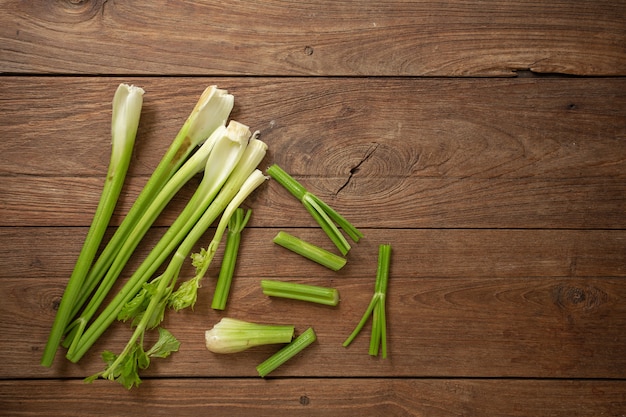 Fresh celery chopped on wooden cutting board and wooden background