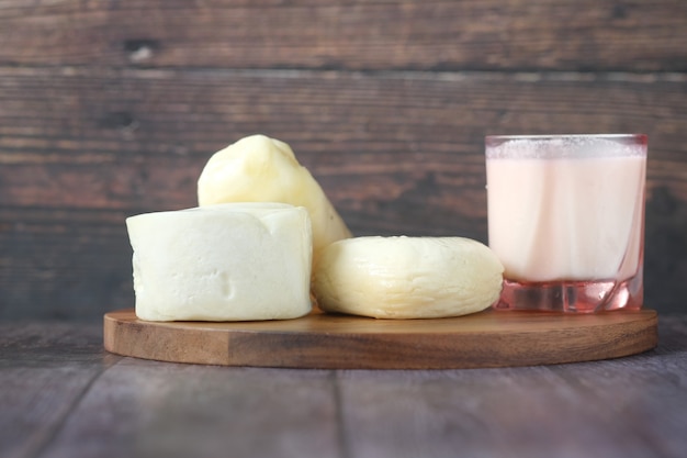 Fresh cheeses on and glass of milk on table