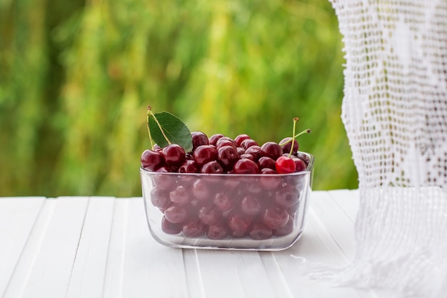 Fresh cherries in glass containers on the table by the window