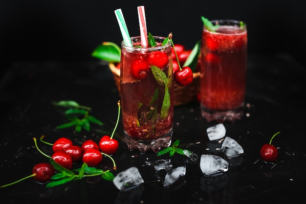 Fresh cherries placed in a basket and black cherries with water splashes