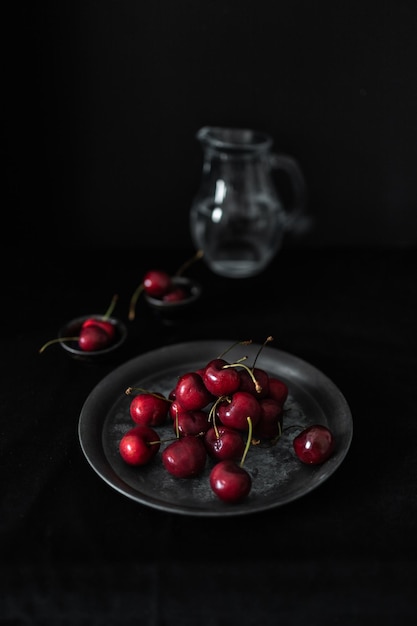 Photo fresh cherries with glass pitcher